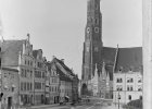 Blick vom Dreifaltigkeitsplatz mit Bürgerhäusern auf die Stadtpfarrkirche St. Martin in Landshut, aufgenommen um 1890. Der 130,6 m hohe Turm aus Ziegelsteinen prägt bis heute die Silhouette der Stadt.